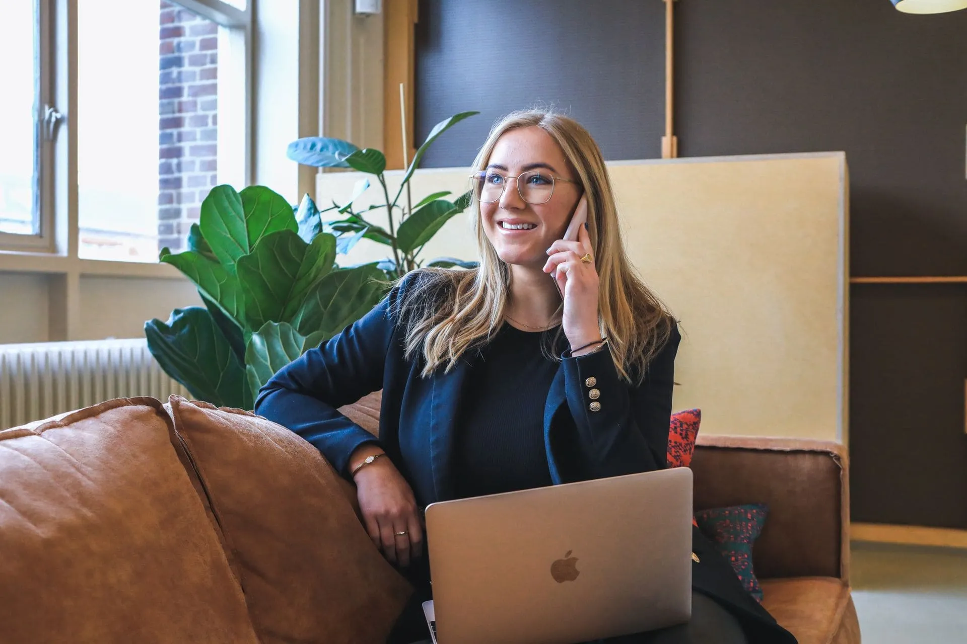 Een professional werkt met een laptop en telefoon in een kantooromgeving.